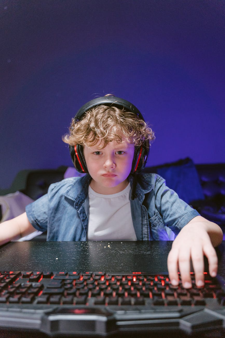 a young boy wearing headphones while playing computer game